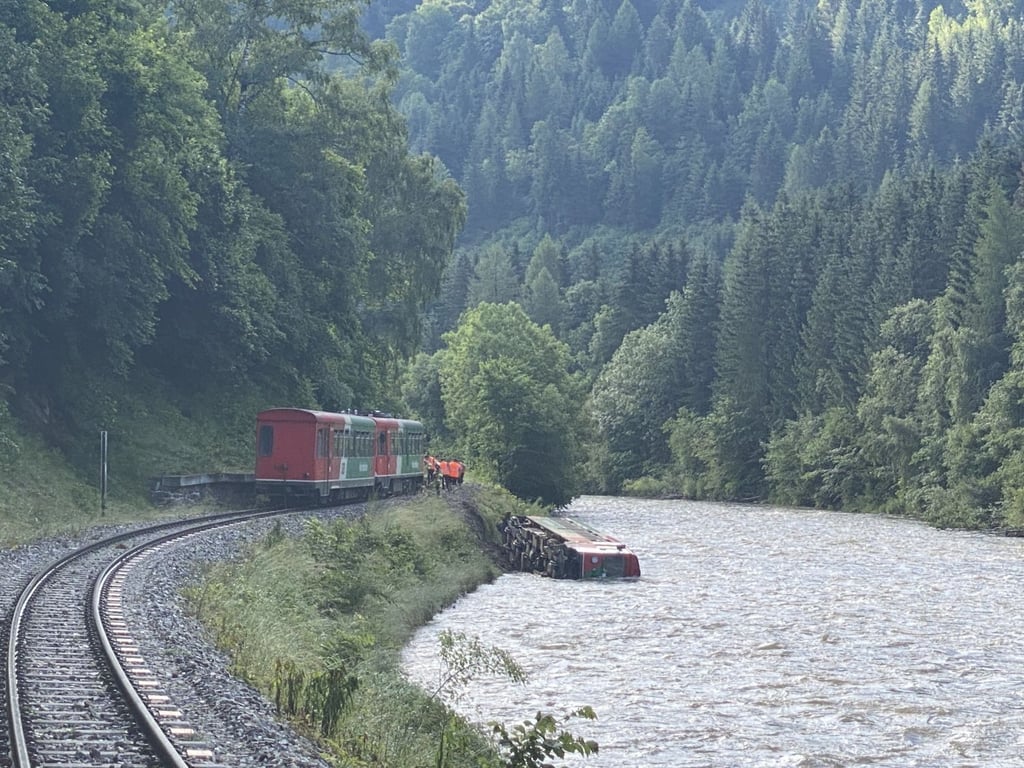 Ein Waggon eines Regionalzugs liegt in der Mur. In Österreich ist ein Zug mit Dutzenden Kindern und Jugendlichen an Bord entgleist und in einen Fluss gestürzt.