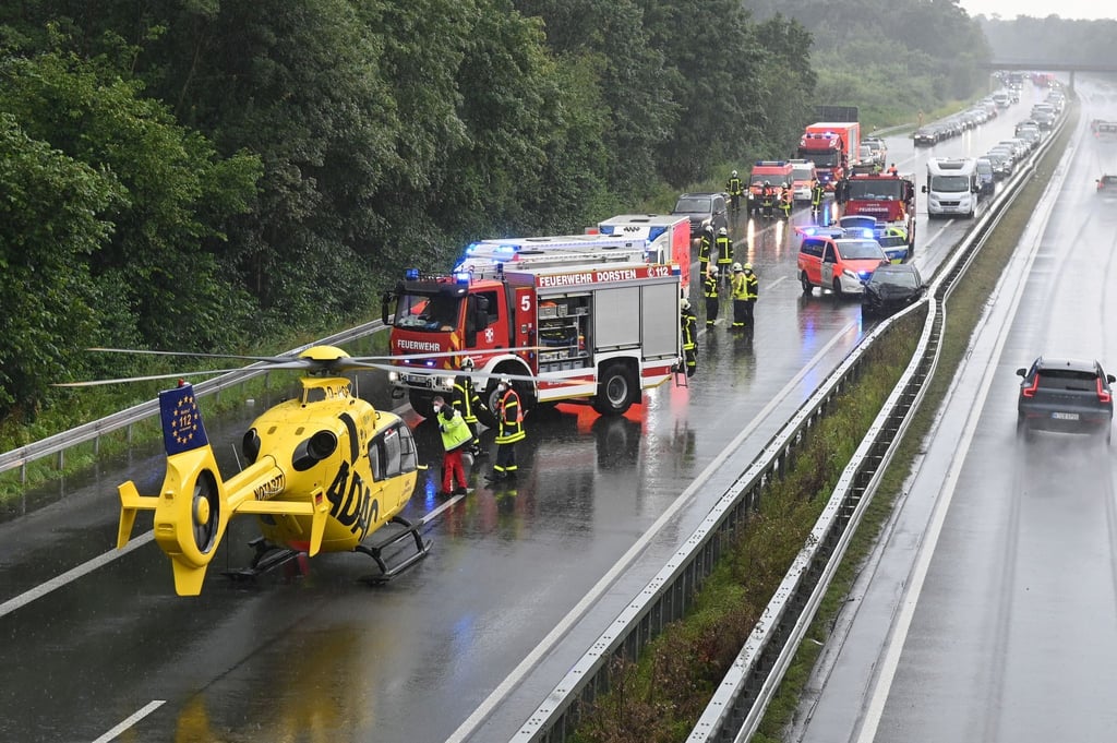 Einsatzkräfte der Feuerwegr und ein Hubschrauber des ADAC stehen auf der A31, wo sich zwei Unfälle ereignet haben.