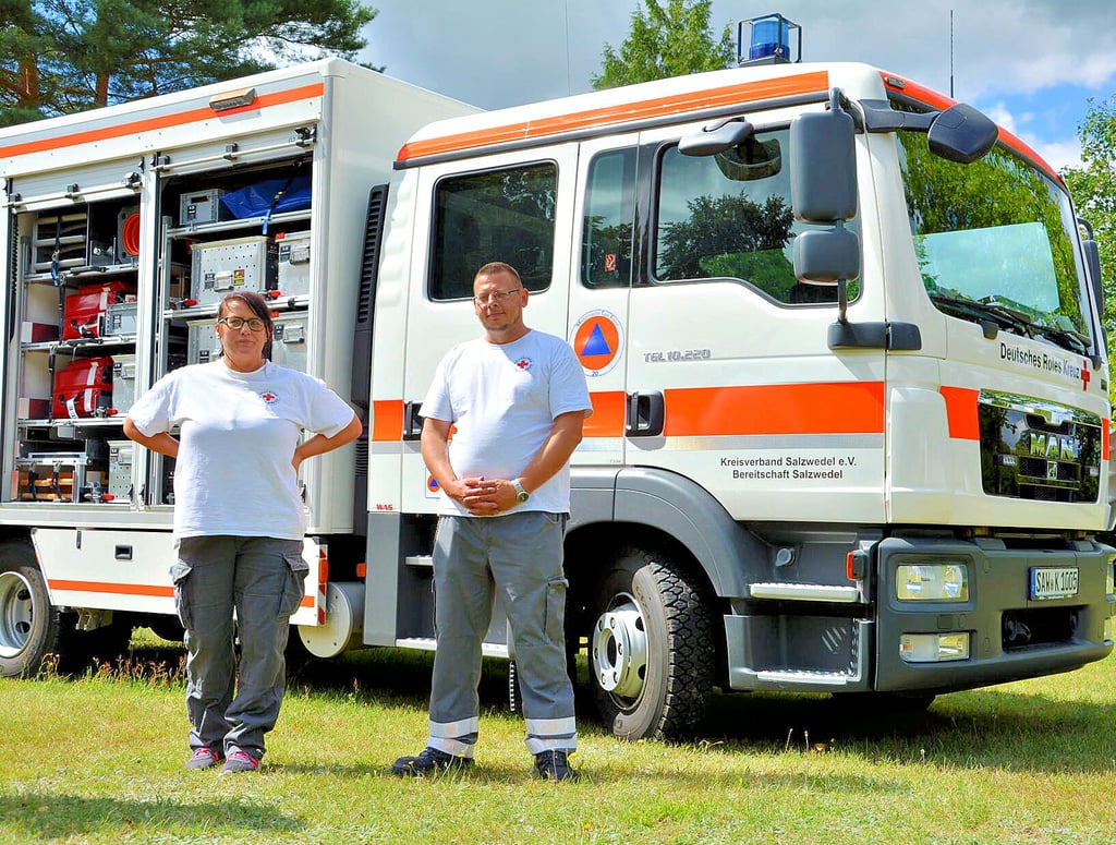 Torsten Meyer und Claudia Müller vom Sanitätszug Salzwedel vor dem Gerätewagen Sanität (GW-San), der bei Großschadenslagen zum Einsatz kommt.