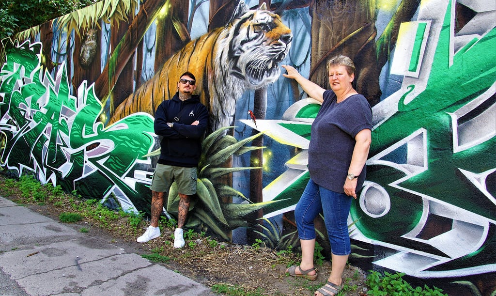 Graffitikünstler Christian und Tiergartenleiterin Anne-Katrin Schulze präsentieren das neue Kunstwerk am Tiergarten in Stendal.