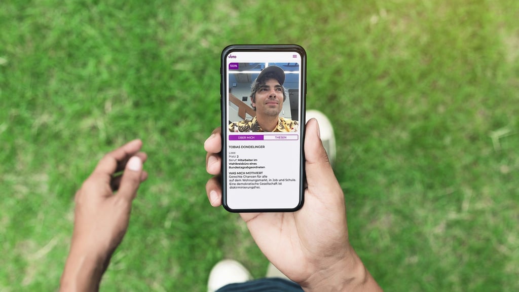 Das Handoutbild zeigt einen Mann, der ein Smartphone mit der digitalen Wahlentscheidungshilfe „Voto“ in der Hand hält.
