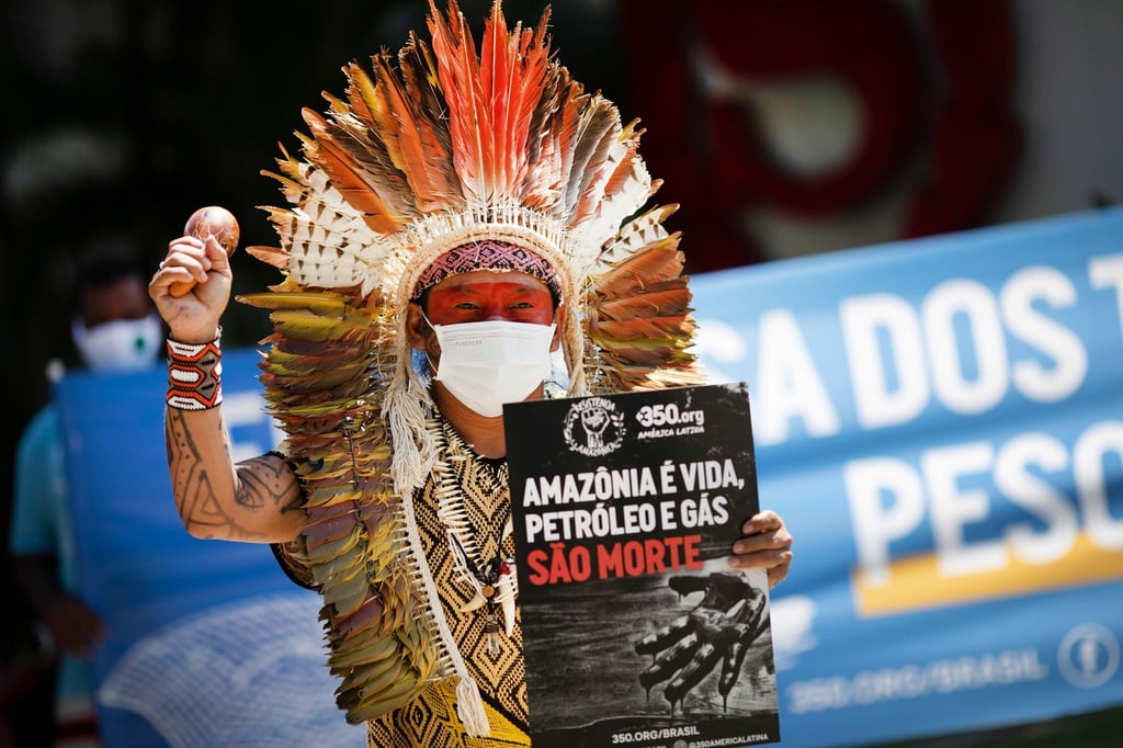 Ninawa Inu Huni kui hält ein Schild mit der Aufschrift „Amazonen ist Leben, Öl und Gas sind Tod“ während eines Protests gegen Auktionen zur Erkundung von Ölfeldern in den Amazonen vor einem Hotel in Rio de Janeiro.