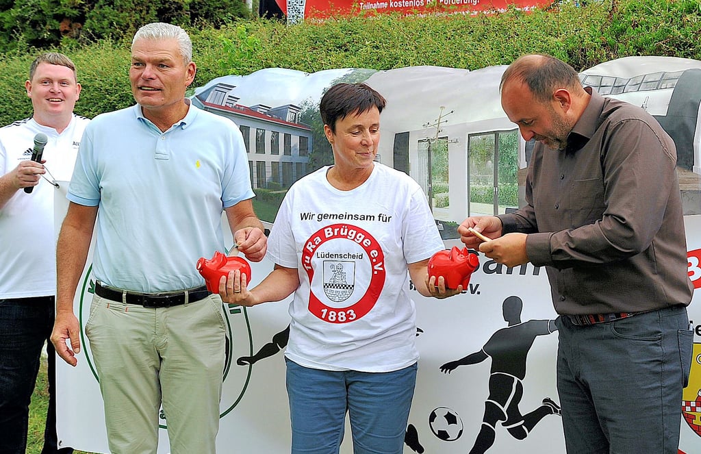 Thomas Staudt(für die Firma Busse) und FSA-Präsident Holger Stahlknecht (links) spenden Geld für den flutgeschädigten Sportverein TuRa Brügge. Katrin Kunert freut es.