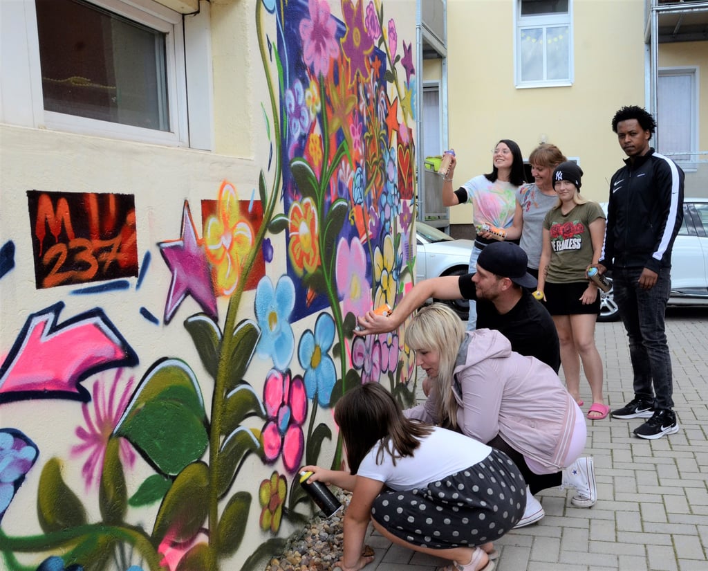 Ein bisschen mehr Farbe in ihren "Sicheren Ort" haben die Bewohner und Pädagogen der traumapädagogischen Wohngruppe am Haldensleber Jungfernstieg gebracht. Initiiert hat das Graffiti-Projekt Betreuerin Paula Grunewald (hinten links), die dafür den Sprayer Matthias Täger (3.v.l.) gewinnen konnte.