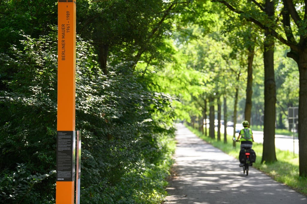 Eine Radfahrerin fährt an der Gedenkstele für Wladimir Iwanowitsch Odinzow vorbei.