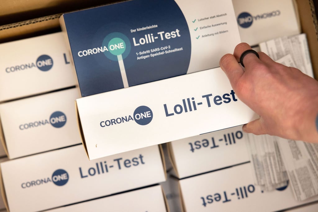 Die Schulleiterin einer Grundschule packt einen „Lolli-Test“ für die Grundschüler zum Nachweis von SARS-CoV-2-Erregern aus.