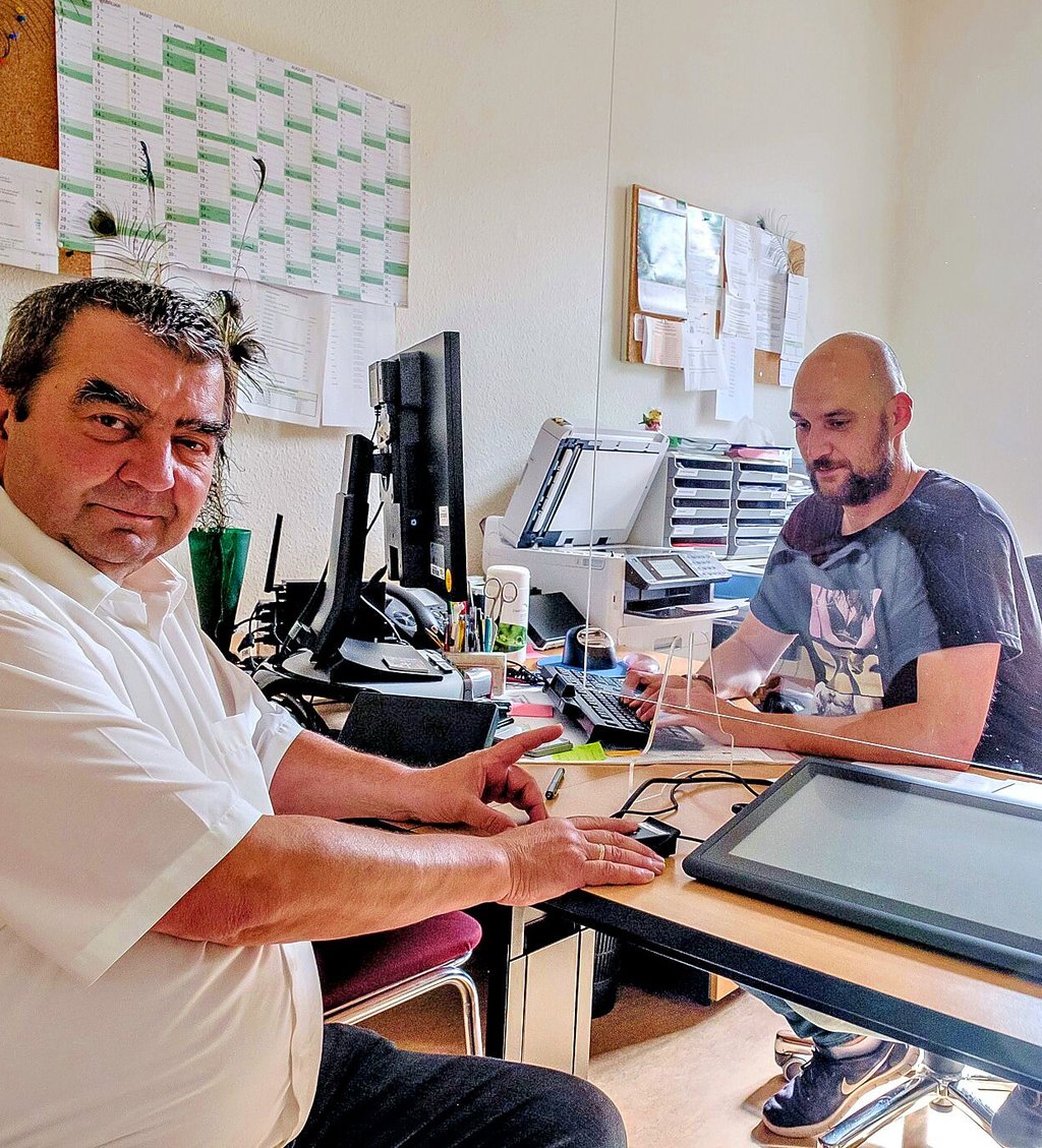 Kembergs Bürgermeister Torsten Seelig (l.) hat den Finger auf dem Gerät, das die Abdrücke elektronisch erfasst.