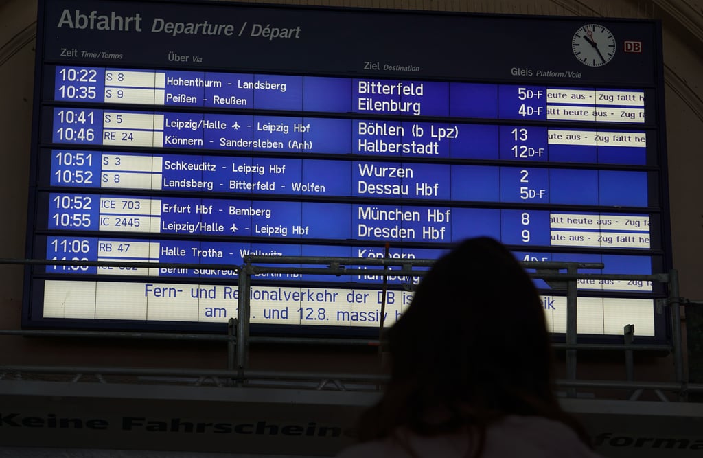 Am Hauptbahnhof Halle (Saale) stehen Reisende vor der Anzeigetafel. Infolge des Streikes der Lokführer fallen viele Züge aus.