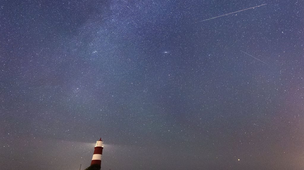 Eine Sternschnuppe ist am Sternenhimmel über dem Leuchtturm zu sehen.