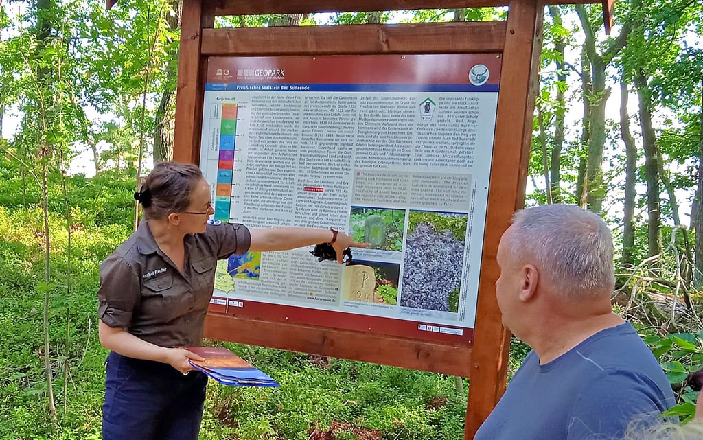 Isabel Reuter vom Regionalverband Harz erläutert die neue Infotafel zum Geopark, aufgestellt in der Nähe des preußischen Saalsteins.