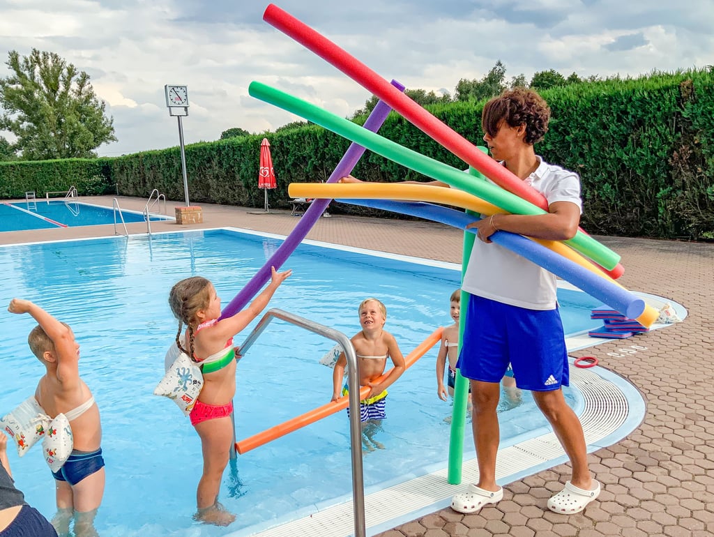 Sissi Frank verteilt die „Schwimmnudeln“ an ihre Schützlinge des aktuellen Schwimmpferdchenkurses im Freibad Zahna.