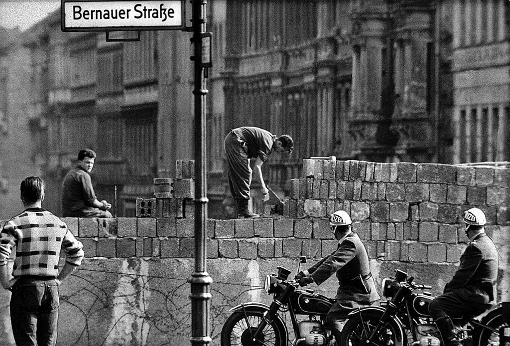 Der Mauerbau quer durch die Bernauer Straße in Berlin.