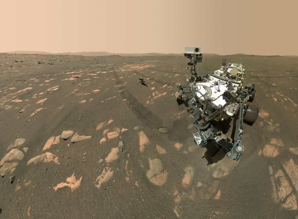 Dieses Handout der US-Raumfahrtbehörde Nasa zeigt den US-Rover „Perseverance“ (r) neben dem Mini-Hubschrauber „Ingenuity“ (M) auf dem Mars.
