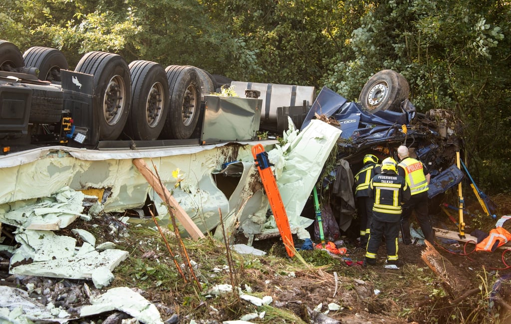 Ein mit Fisch beladener Sattelzug liegt neben der Autobahn A24 an einer Unfallstelle.
