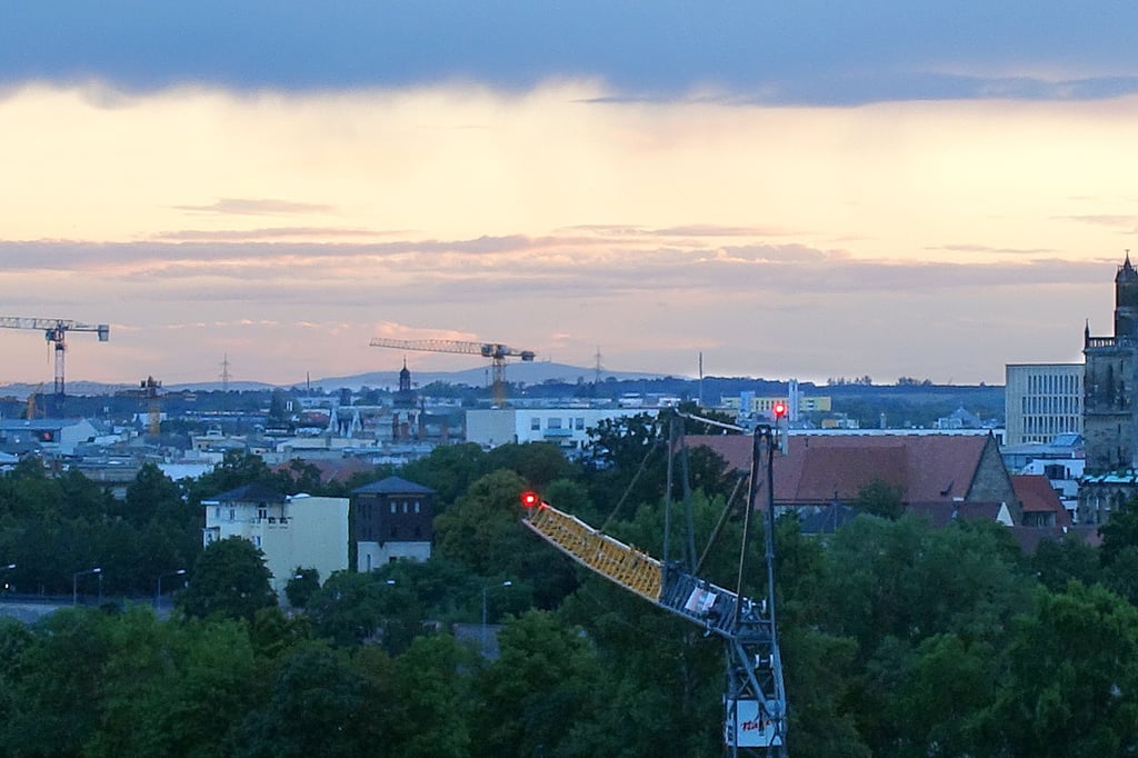 Baukräne über Magdeburg und am Horizont der Brocken.