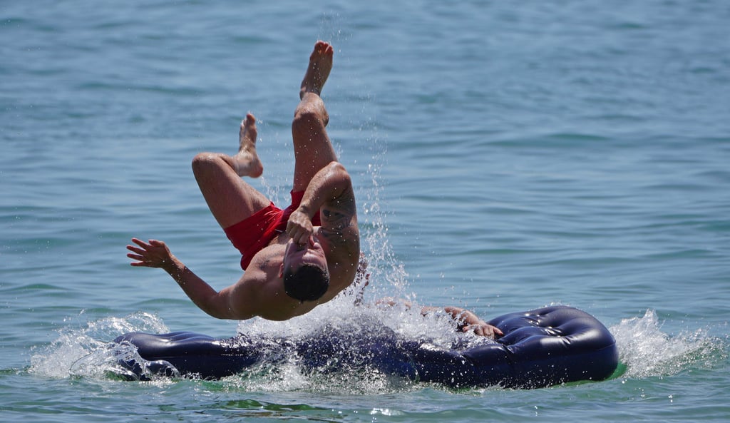 Ein Mann springt von einer Luftmatratze ins Wasser. In Sachsen-Anhalt herrschen an diesem Wochenende beste Bade-Bedingungen.