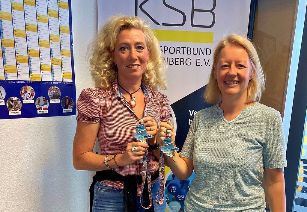 Doreen Meyer (li.) und Katrin Pahnke-Meyer (KSB) mit der Medaille, die es für die Teilnahme am 10. Wittenberger Nachtlauf gibt und die Doreen Meyer entworfen hat.