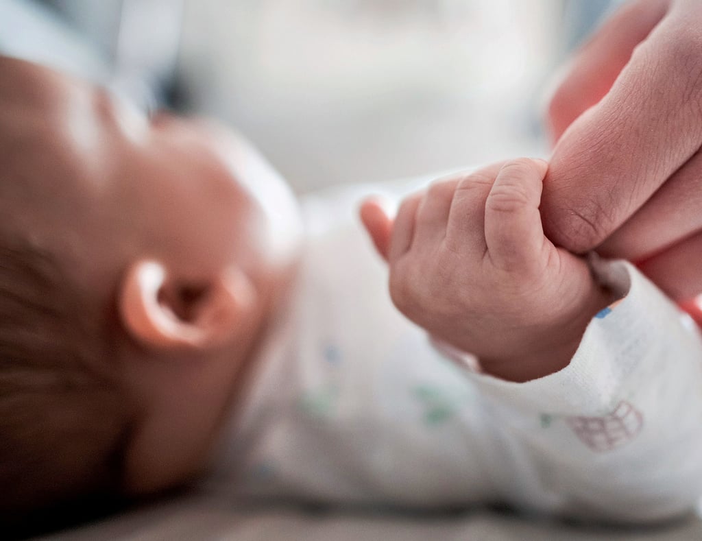 Ein Baby klammert sich an den Finger seiner Mutter ? ein erstes Kennenlernen zwischen Mitter und Kind. Die Zeit auf der Wochenstation soll dazu dienen, sich von der Geburt zu erholen und mit dem Kind vertraut zu machen. Coronabedingte strenge Besuchsregeln schließen Väter aus dieser wichtigen Zeit mitunter aus.