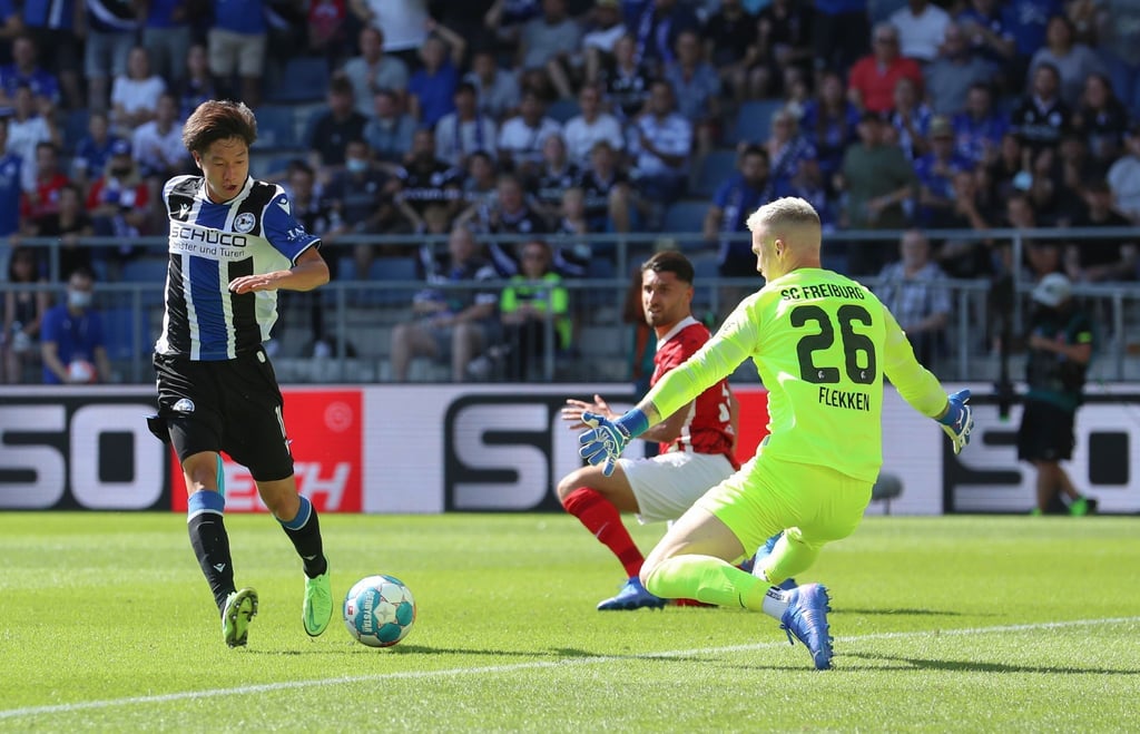 Bielefelds Masaya Okugawa (l) scheitert an Freiburgs Torwart Mark Flekken.