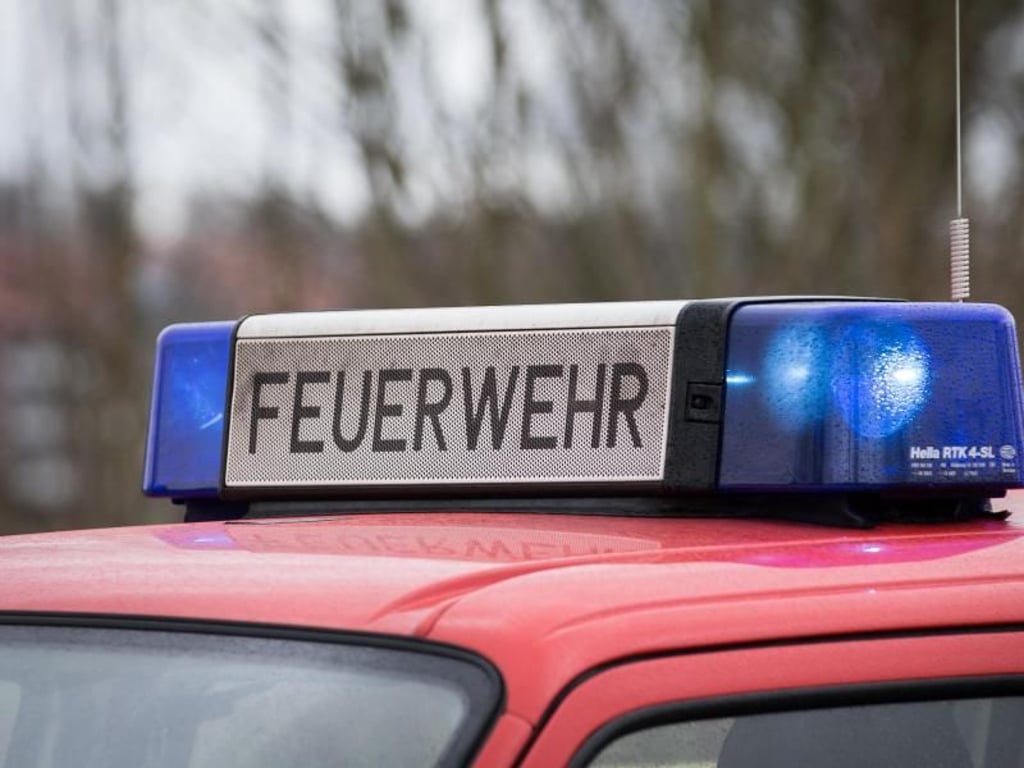 Das Blaulicht eines Feuerwehrautos leuchtet an einem Einsatzort. 
