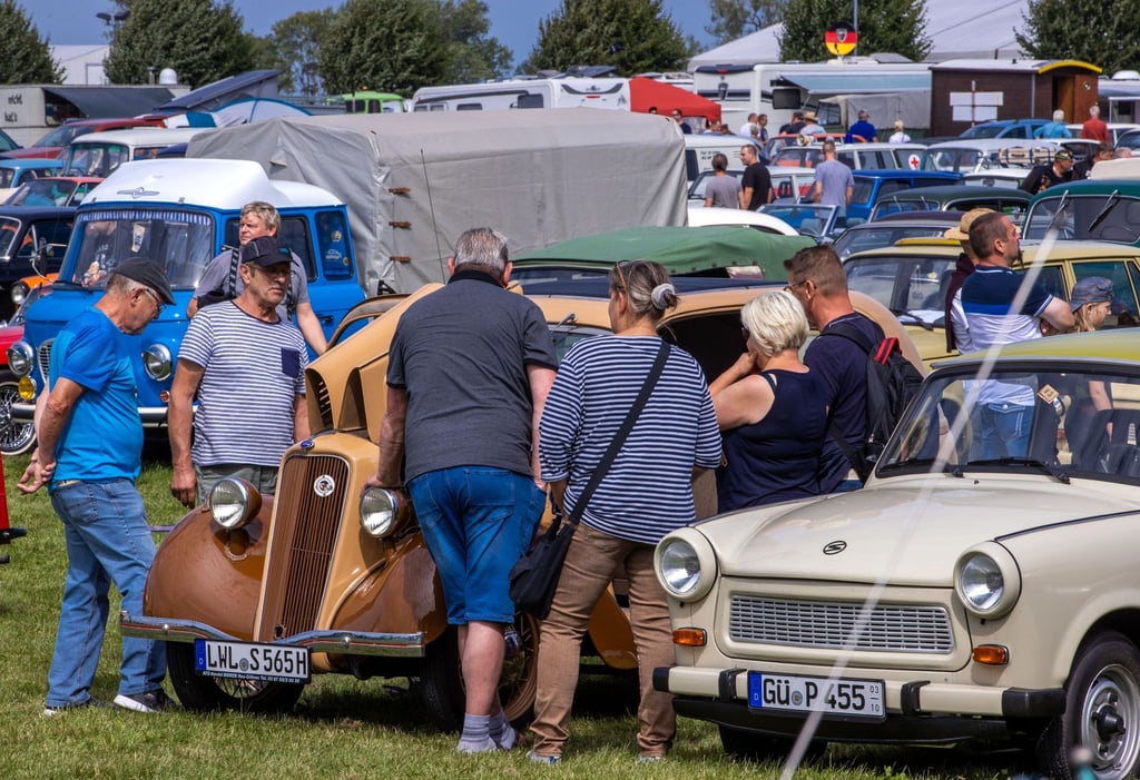 Besucher der Oldtimertage Mühlengeez sehen sich ein Fahrzeug an.