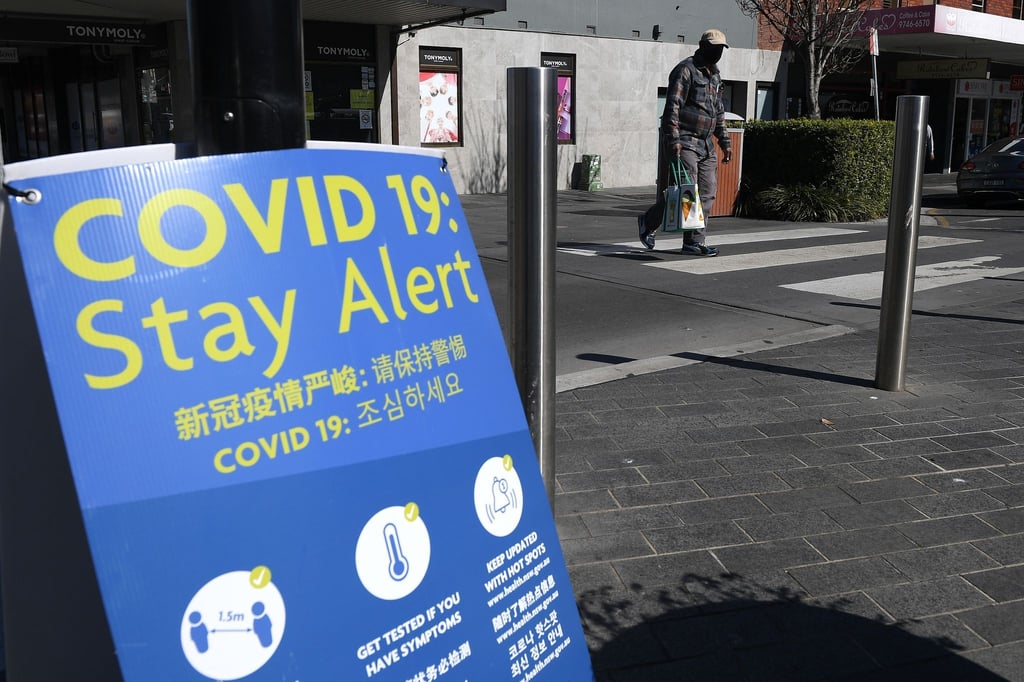 Ein Schild mit den Corona-Regeln an einer Straße in Sydney.