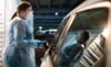 Eine Helferin testet Insassen eines Autos im „Testzentrum am Zoo“ in Hannover.