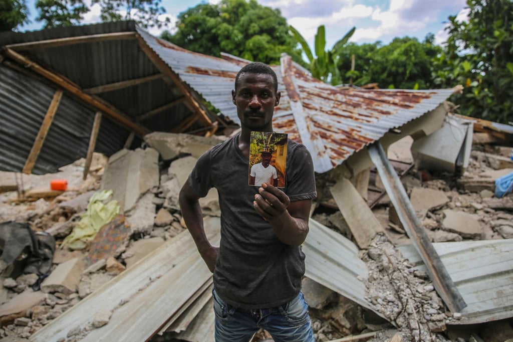 Ein Haitianer mit einem Foto seines bei dem Erdbeben ums Leben gekommenen Bruders.