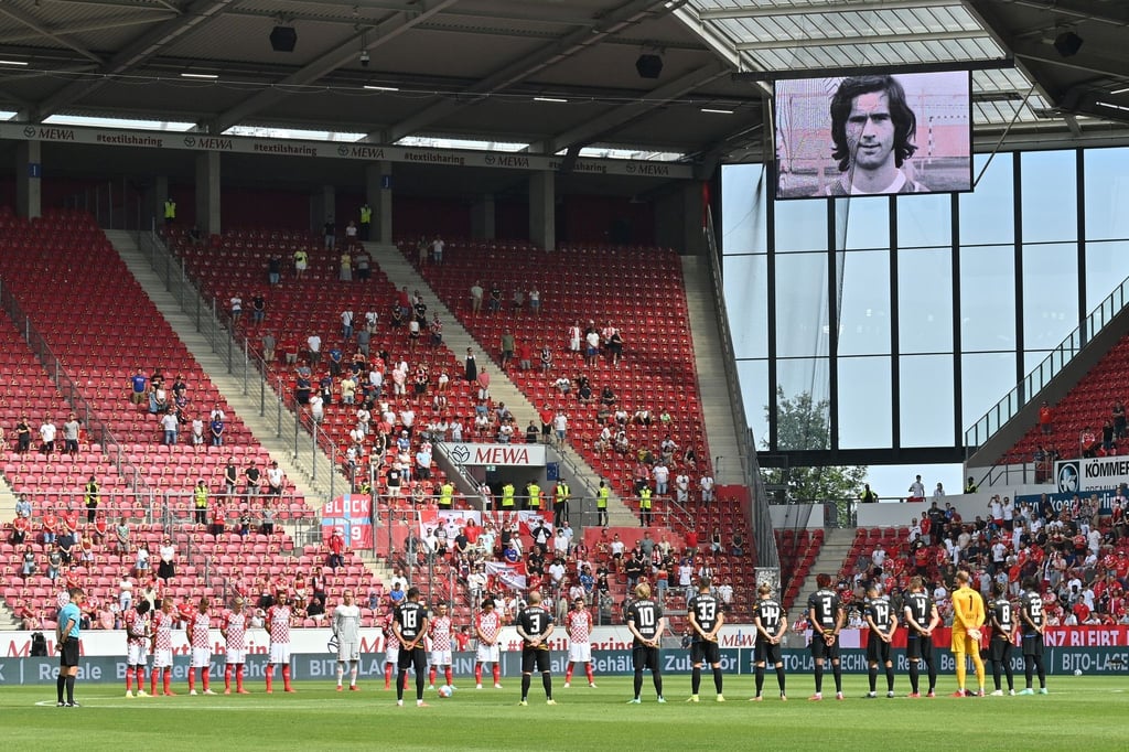 Die Spieler stehen für eine Schweigeminute für den verstorbenen früheren Fußball-Nationalspieler Gerd Müller, dessen Bild auf der Anzeigetafel zu sehen ist, auf dem Platz.