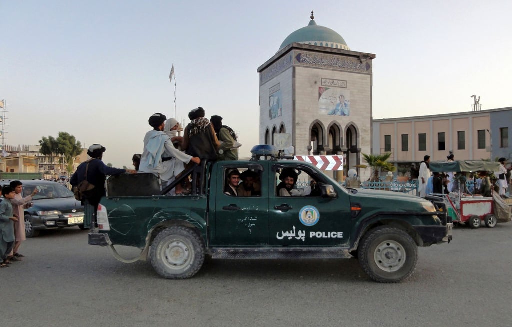Taliban-Kämpfer patrouillieren in einem Polizeifahrzeug in Kandahar.