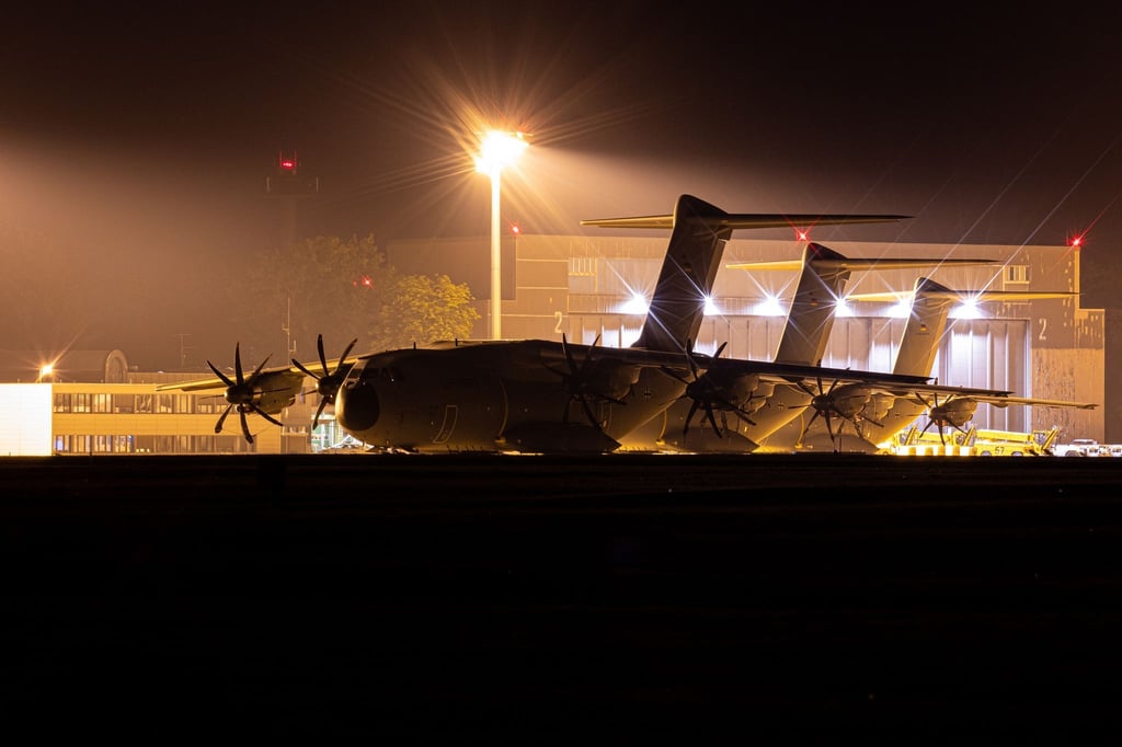 Transportflugzeuge vom Typ Airbus A400M der Luftwaffe stehen am Abend auf dem Fliegerhorst Wunstorf in der Region Hannover hinter einem Zaun.