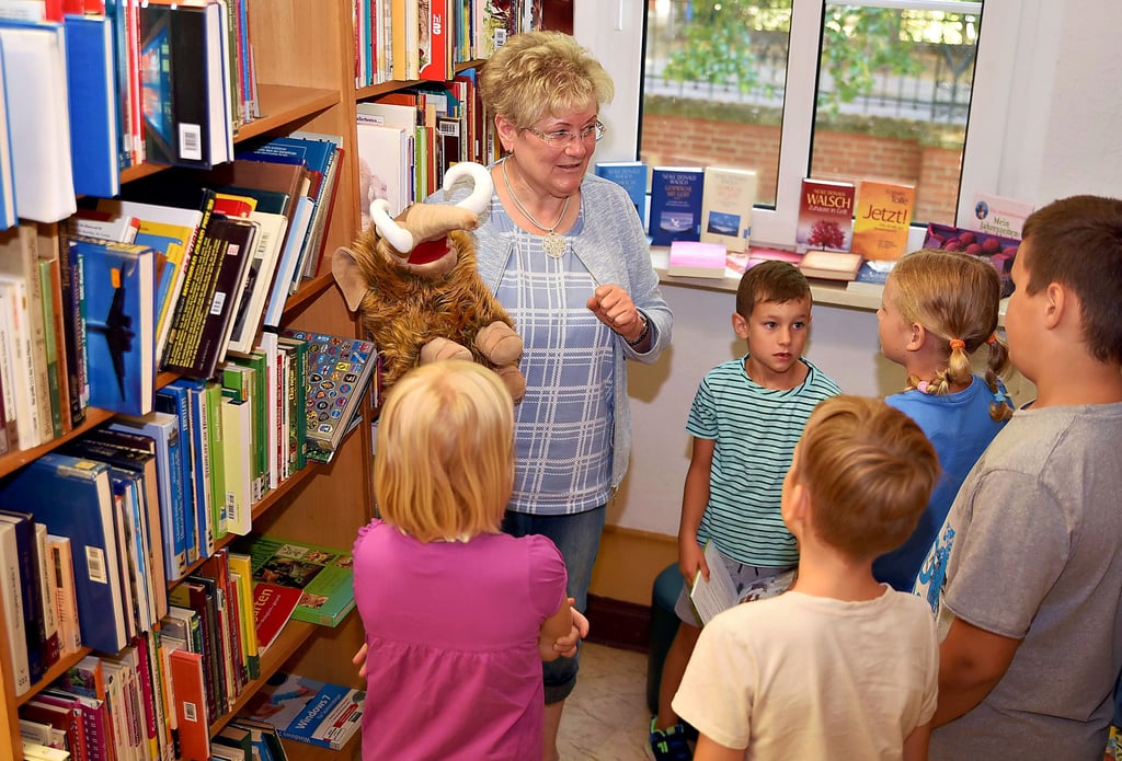 Bei einem Rundgang stellt Bibliotheksleiterin Martina Schrader den Hortkindern auch Mammut Manni, das Maskottchen der Einrichtung, vor.