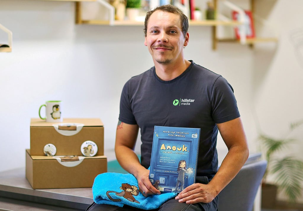 Christian Lehmann zeigt das Buch ?Anouk, die nachts auf Reisen geht? und ein paar Fanartikel.