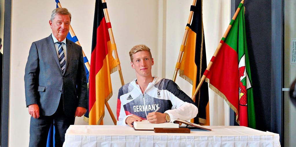 Olympiasieger Florian Wellbrock trägt sich vor den Augen von Magdeburgs Oberbürgermeister Lutz Trümper in das Goldene Buch der Stadt ein. Für den 23-Jährigen war es bereits der vierte Eintrag. Auch alle weiteren Magdeburger Olympia-Starter durften sich mit einer Unterschrift in dem Buch verewigen.
