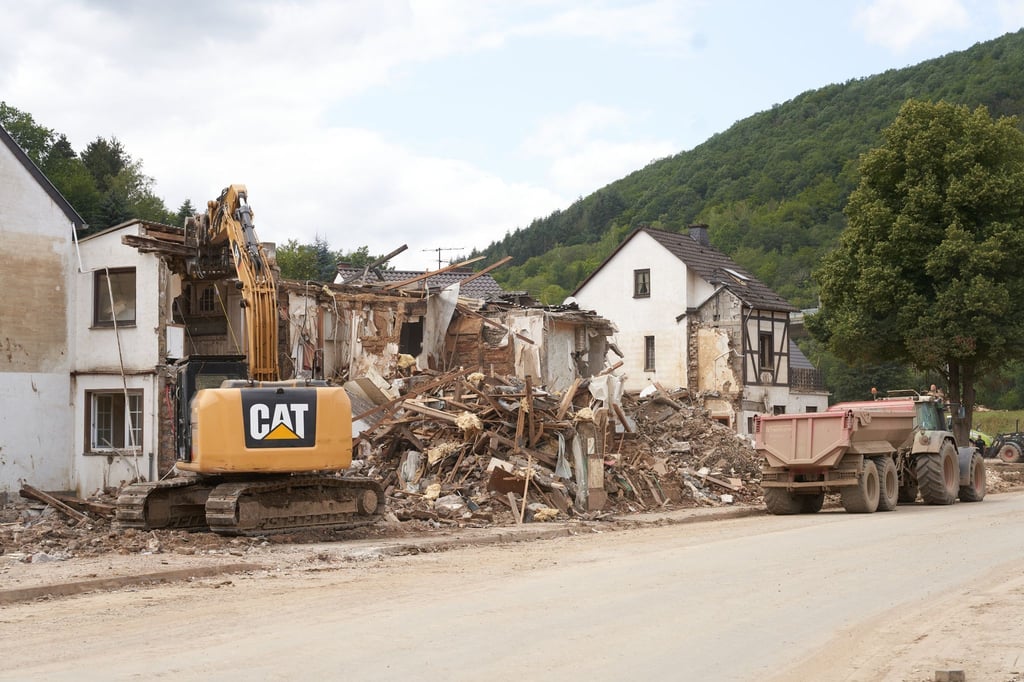 Ein Bagger reisst in Altenburg (Rheinland-Pfalz) Häuser ab, die durch die Flutkatastrophe zerstört wurden.