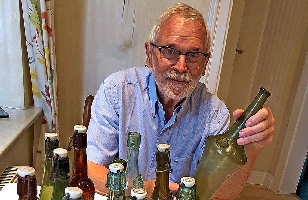 Günter Wagener zeigt einen Teil seiner Sammlung mit der mundgeblasenen Bierflasche.