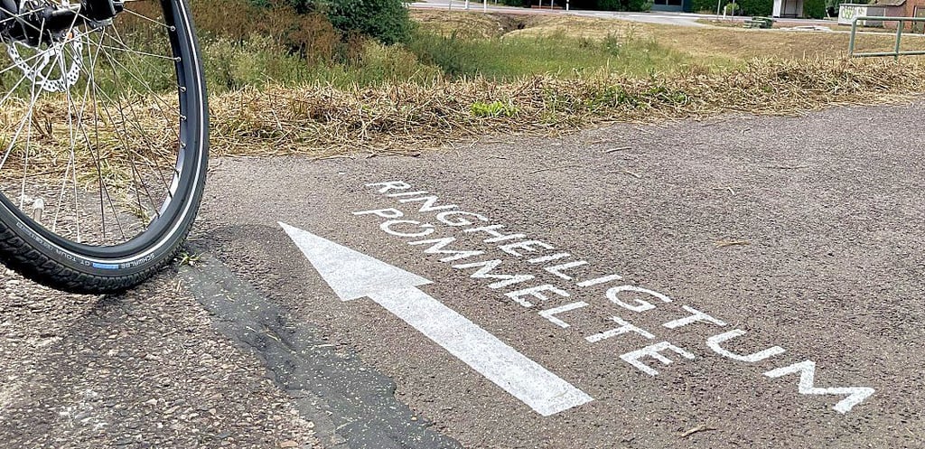 Pömmeltes Ortsbürgermeister Peter Liensdorf fotografierte den neuen Hinweis auf dem Radweg zum Ringheiligtum.