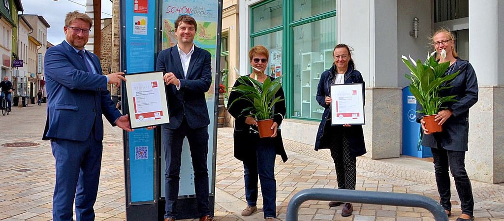 Schönebecks Oberbürgermeister Bert Knoblauch (links), Solepark-Leiterin Sibylle Schulz (Mitte) und ihre Mitarbeiterin Karin Friedrich (rechts) freuen sich über die erneute Zertifizierung, die durch Martin Schulze (Tourismusverband Sachsen-Anhalt) und Melanie Diedrich-Schüller (Magdeburger Tourismusverband Elbe-Börde-Heide) vor der Stadtinformation Am Markt überreicht wurde.