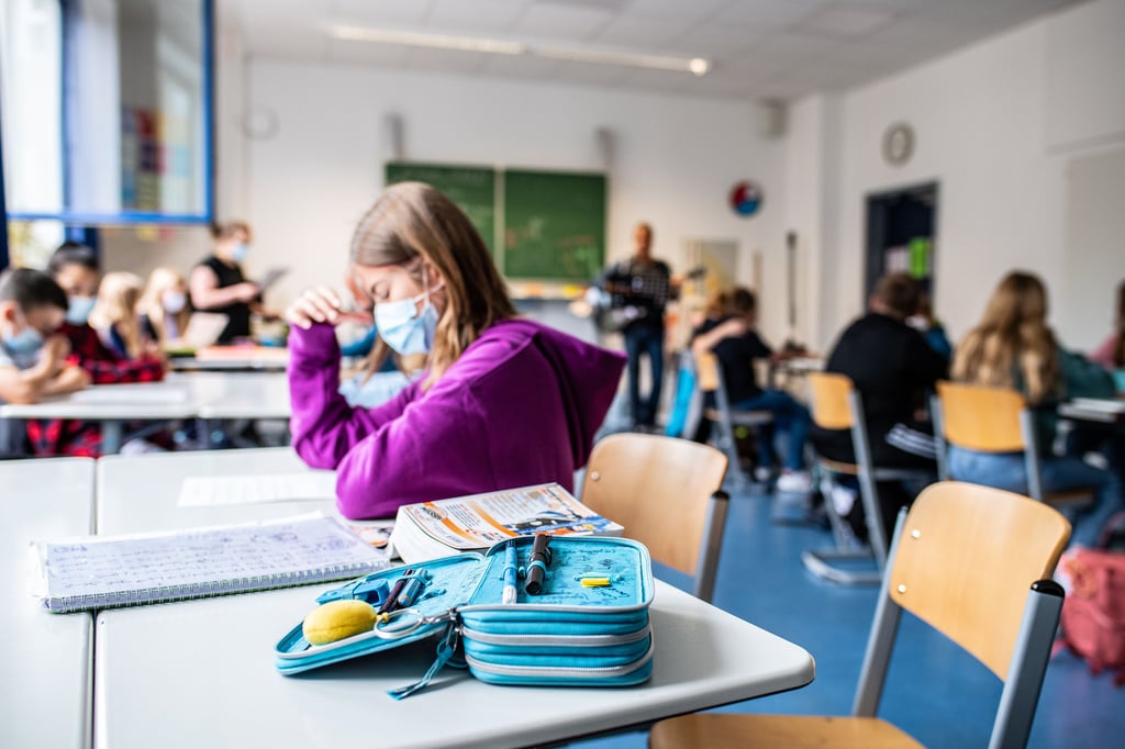 Schülerin mit medizinischer Maske im Unterricht: Viele Lehrer sehen erhebliche Lerndefizite infolge der Pandemie. Sachsen-Anhalt begegnet dem unter anderem mit Lerncamps und einem Nachholprogramm.
