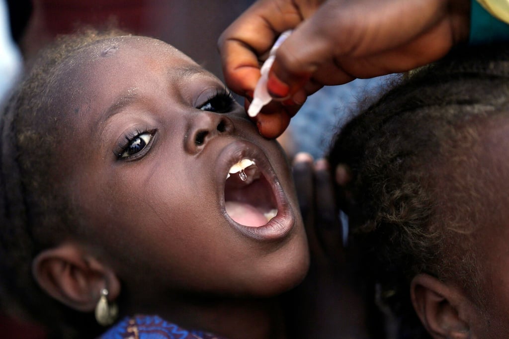 Eine Mitarbeiterin des Gesundheitswesens impft ein kleines Mädchen gegen Polio in einem Lager für Geflüchtete in Nigeria.