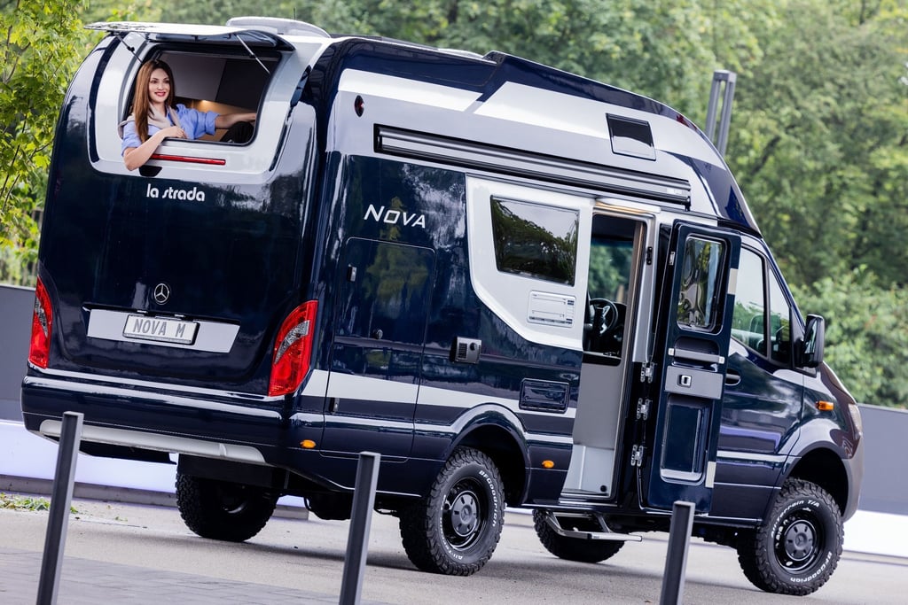 Model Frieda sitzt in dem Wohnmobil La Strada Nova M 4x4 mit Offroad-Reifen und Allradantrieb bei einem Fototermin zum 60. Caravan Salon der Messe Düsseldorf.