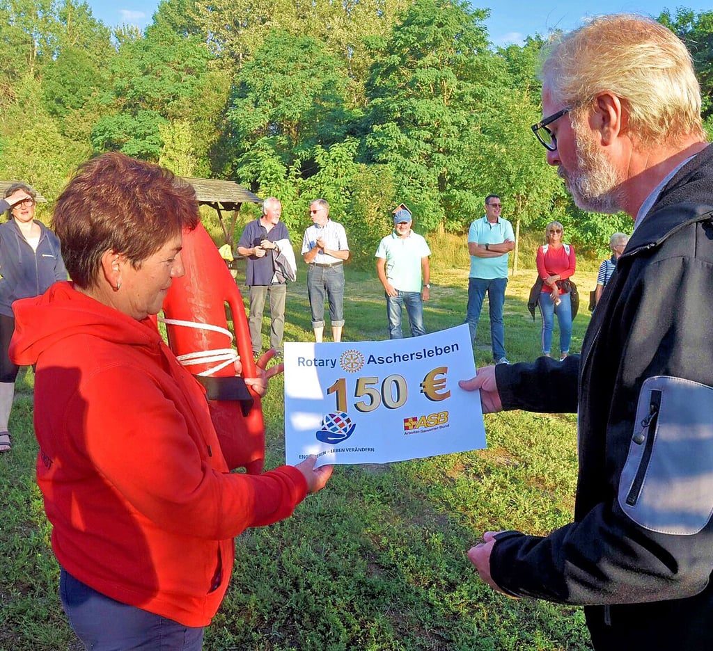 Rotary-Präsident Axel Wieczorek überreicht Uta Krauß von der ASB-Wasserrettung einen Scheck über 150 Euro, der die Nachwuchsarbeit der Rettungsschwimmer unterstützen soll.
