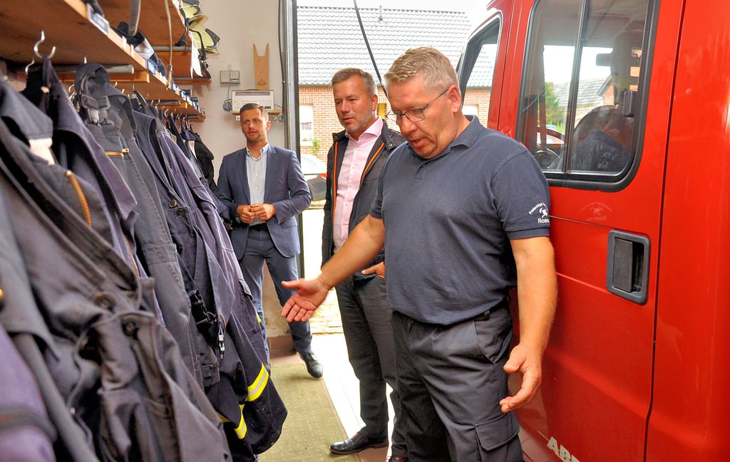 Ortswehrleiter Enrico Brun (von rechts) zeigt Bürgermeister Nico Schulz und dem Landtagsabgeordneten Chris Schulenburg mit der in der Fahrzeughalle untergebrachten Umkleide einen kritikwürdigen Zustand im heutigen Gerätehaus. Abseits davon verfügt der Stützpunkt weder über eine Waschgelegenheit noch über Toiletten.