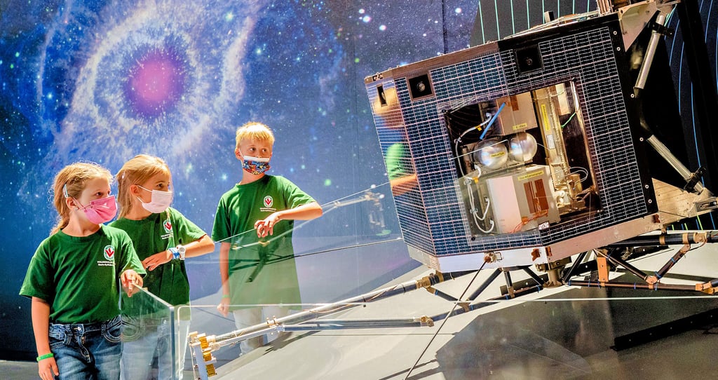 Marie, Liah und Jan (v.l.) vom Hort „Quernekids“ Querfurt sehen sich in der „Arche Nebra“ den 1:1-Nachbau des Landeroboters Philae der Rosetta-Sonde an.