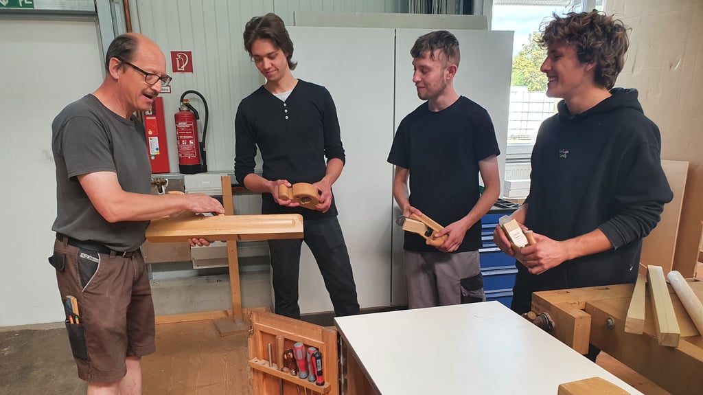 Lehrausbilder und Altgeselle Peter Busse, der seit über 30 Jahren bei der Firma Kiebitzberg beschäftigt ist, macht die neuen Auszubildenden Dominik Kolke, Leon Baumgartner und Arthur Warnkroß (von links) mit ersten Tischlerwerkzeugen vertraut.