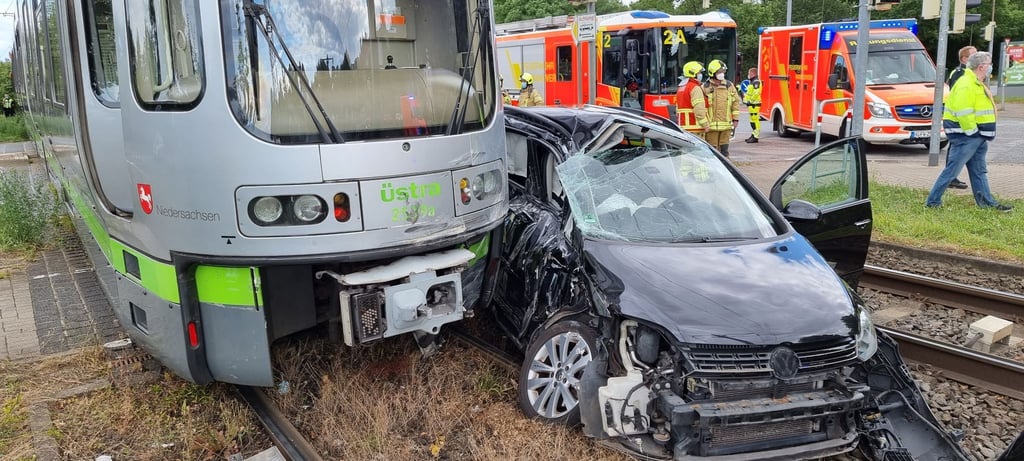 Eine Straßenbahn und ein Auto stehen nach der Kollision auf den Schienen.