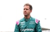 Aston Martin-Pilot Sebastian Vettel steht mit nachdenklicher Miene im Fahrerlager.