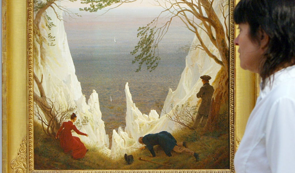 Eine Besucherin schaut sich während einer Ausstellung Caspar David Friedrichs Gemälde "Kreidefelsen auf Rügen" an.