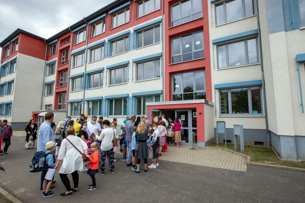 Schulanfänger und ihre Eltern warten auf Corona-Kontrollen und gehen zur Einschulungsfeier.