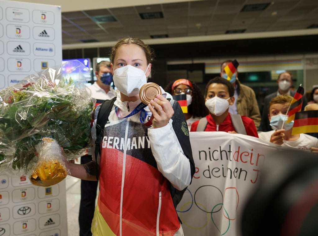 Sarah Köhler steht mit ihrer Bronzemedaille nach ihrer Ankunft aus Tokio auf dem Frankfurter Flughafen.